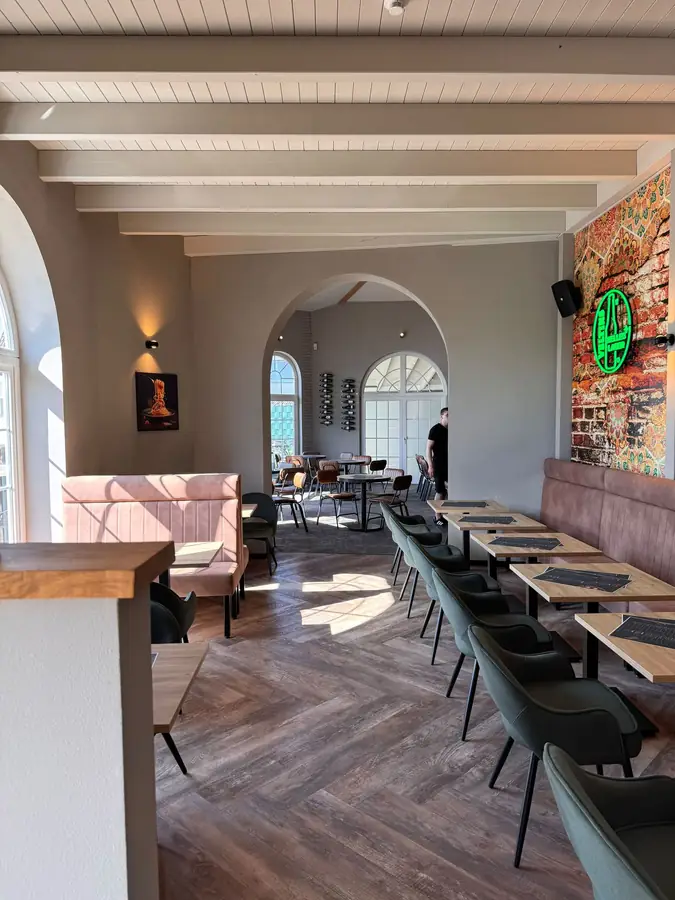 Innenraum der Osteria Nova mit Arkadenbögen, Wandgemälde und warmem Licht