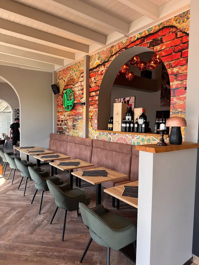 Warmer Innenraum der Osteria Nova mit großen Fenstern zum See